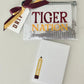 Clear pouch with 'Tiger Nation' text, pencil-shaped notepad, and decorative ribbon on a light gray background